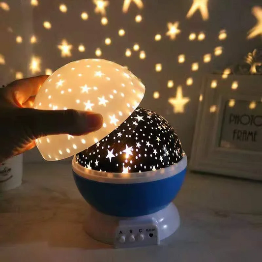 Starry night light projector with stars projected onto a wall