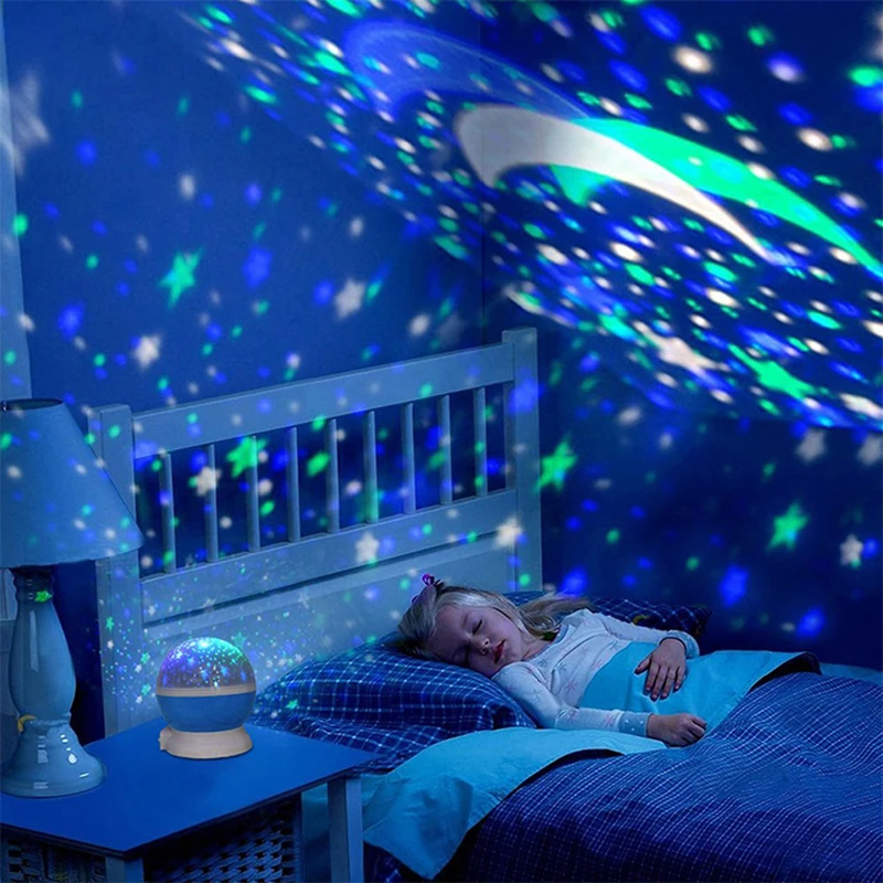 Child lying in bed under a starry night sky projection in a bedroom.