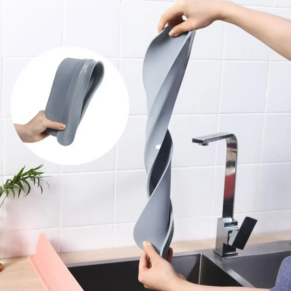 Person holding a gray kitchen sponge with a unique design over a sink.