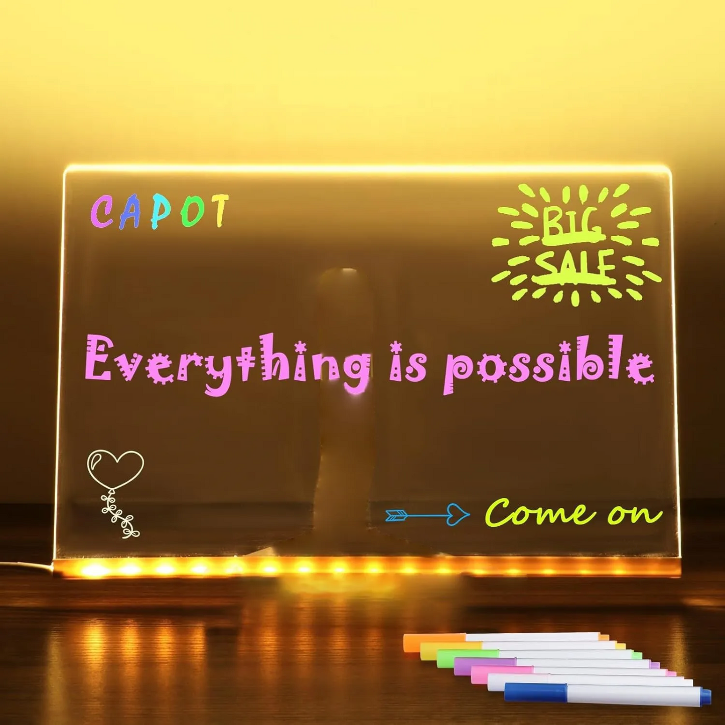 Light-up board with motivational messages and markers on a wooden surface
