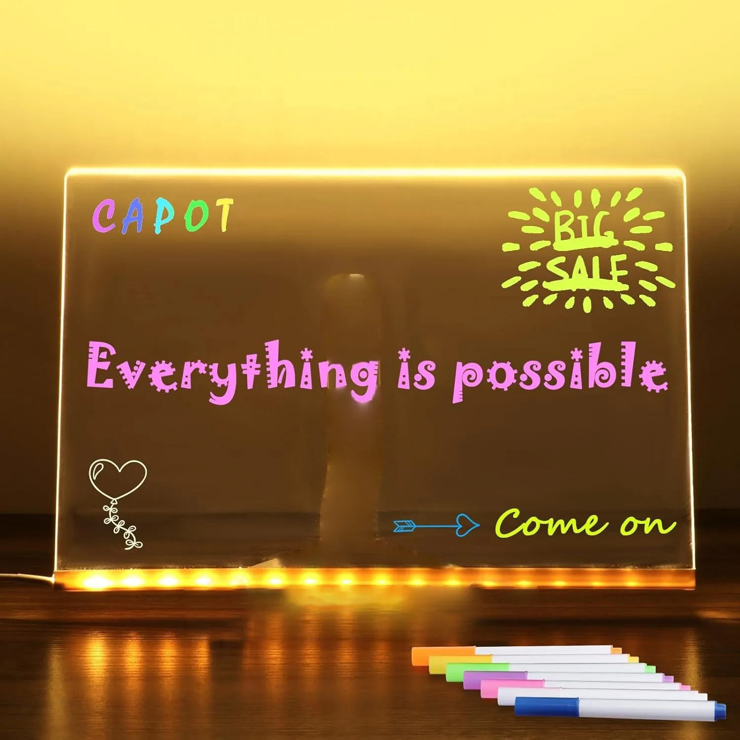 Light-up board with motivational messages and markers on a wooden surface