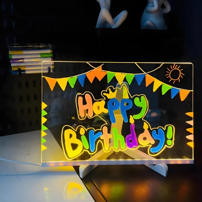 Glowing 'Happy Birthday!' card with colorful letters on a stand against a dark background.